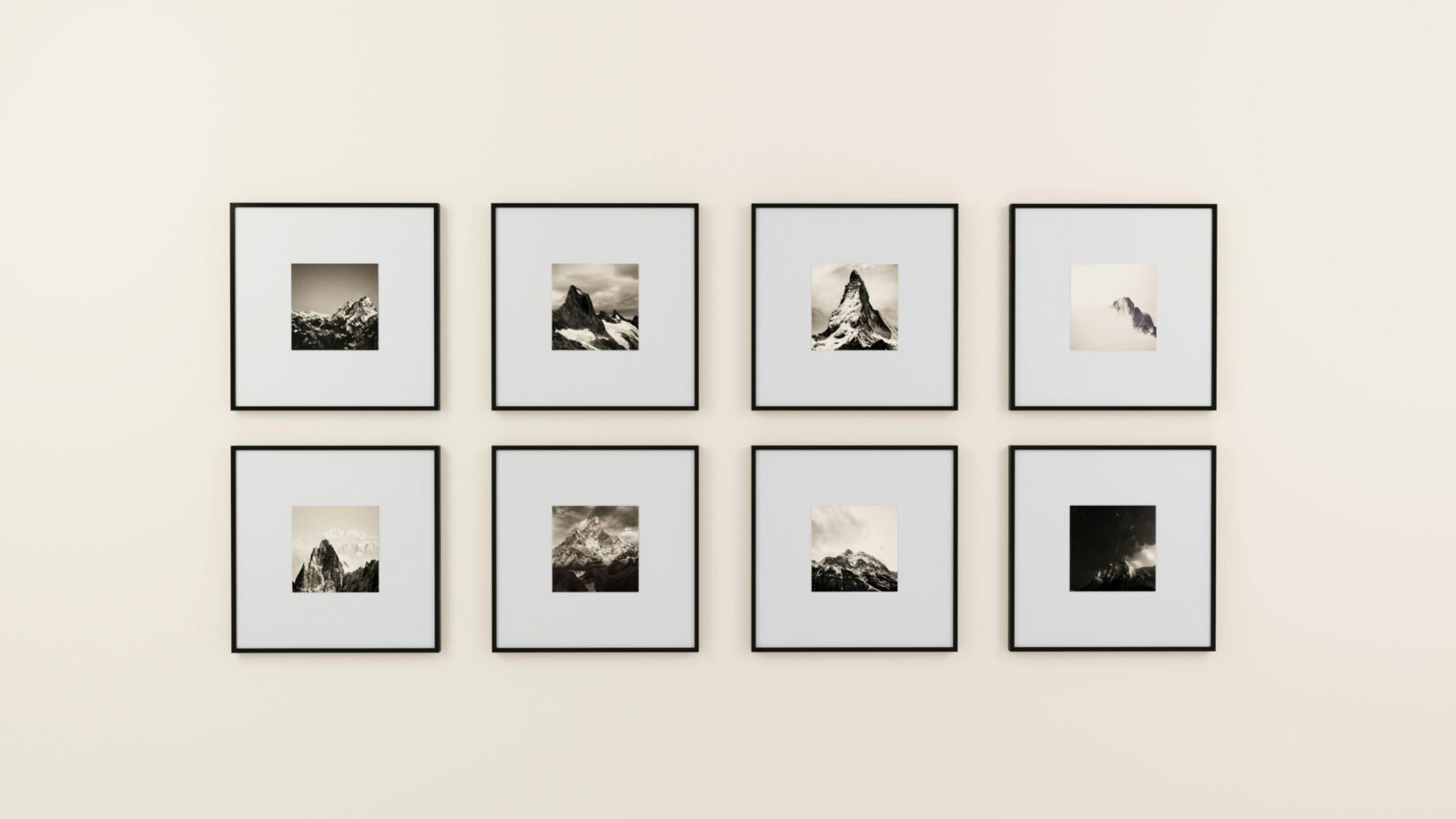 A minimalist display of framed mountain photography on a plain wall.